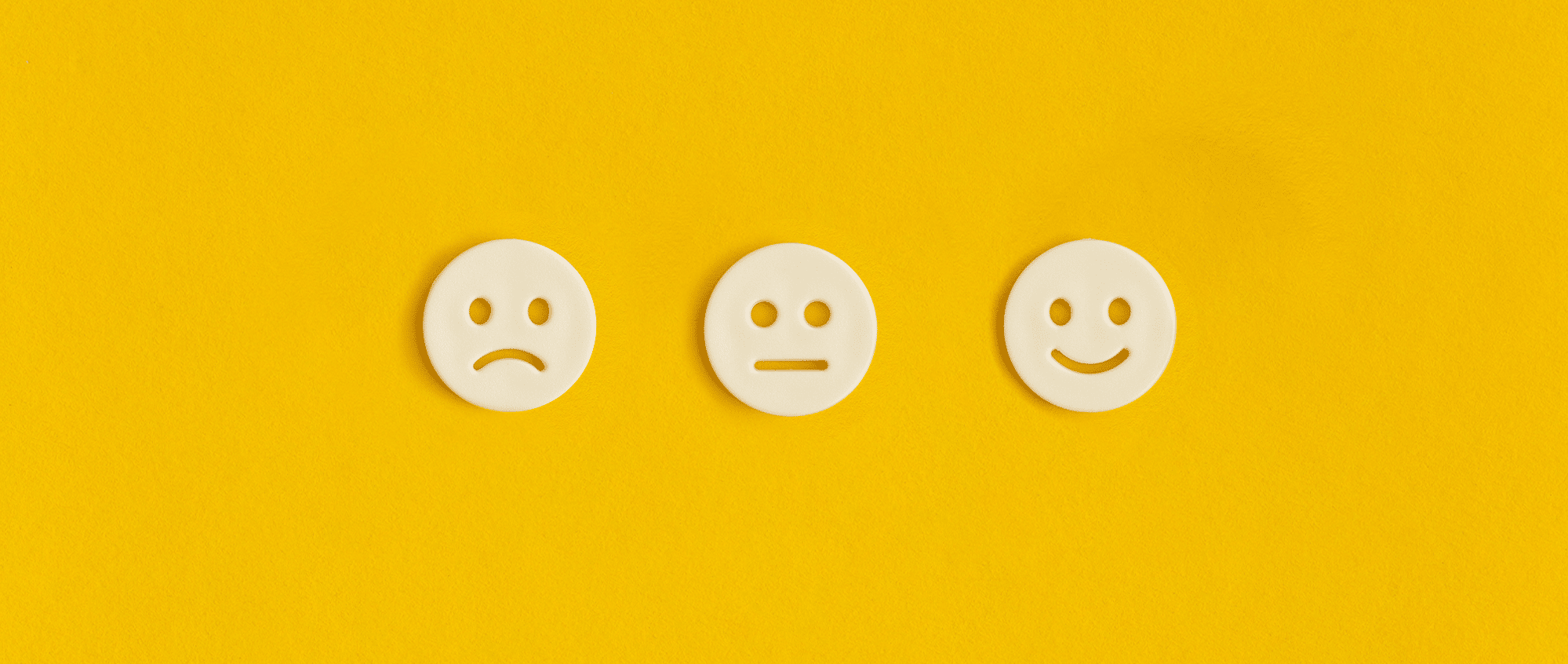 a series of smiley faces that show sadness, neutrality, and happiness
