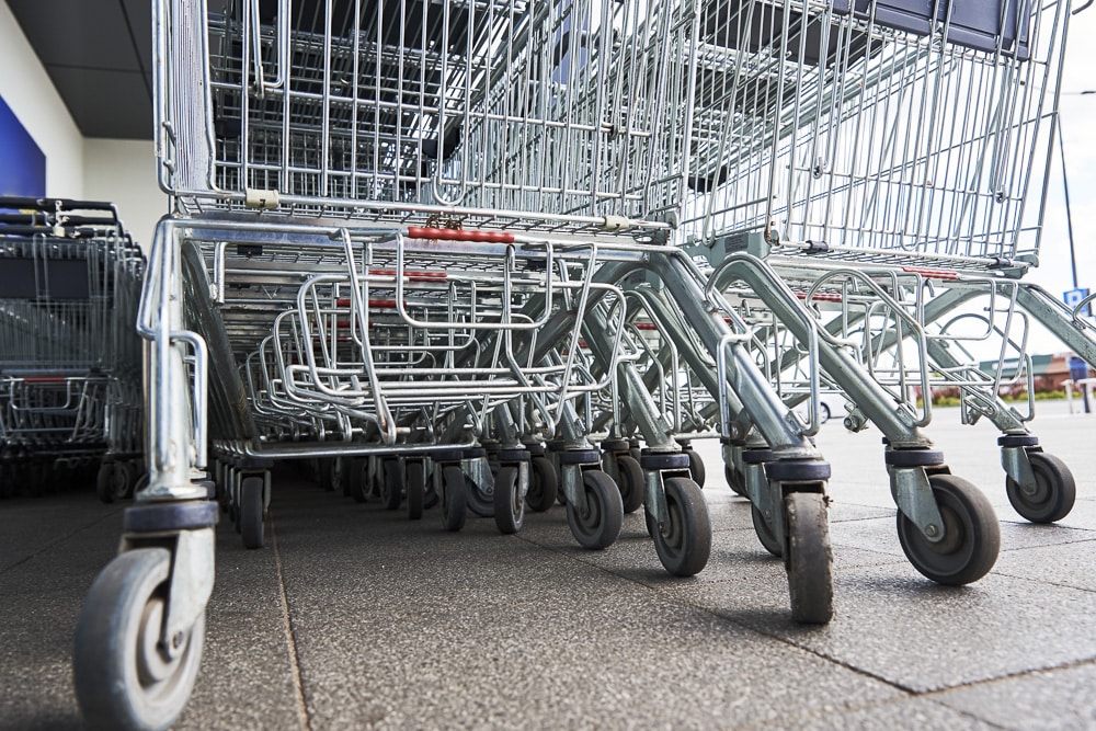 Many empty shopping carts on the shop parking. Row of shopping trolleys for supermarket buyers